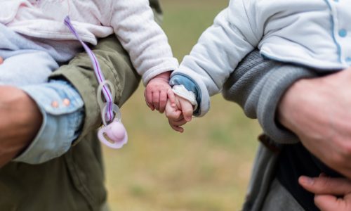 Bild på två barn som håller hand.
